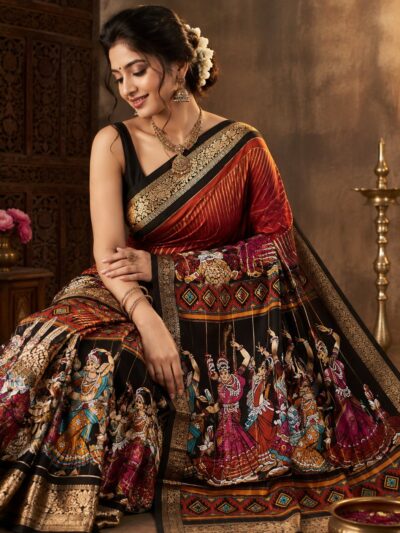 Woman wearing a black Kalamkari saree with a printed dancing figure design, rust red pallu and wide gold zari border